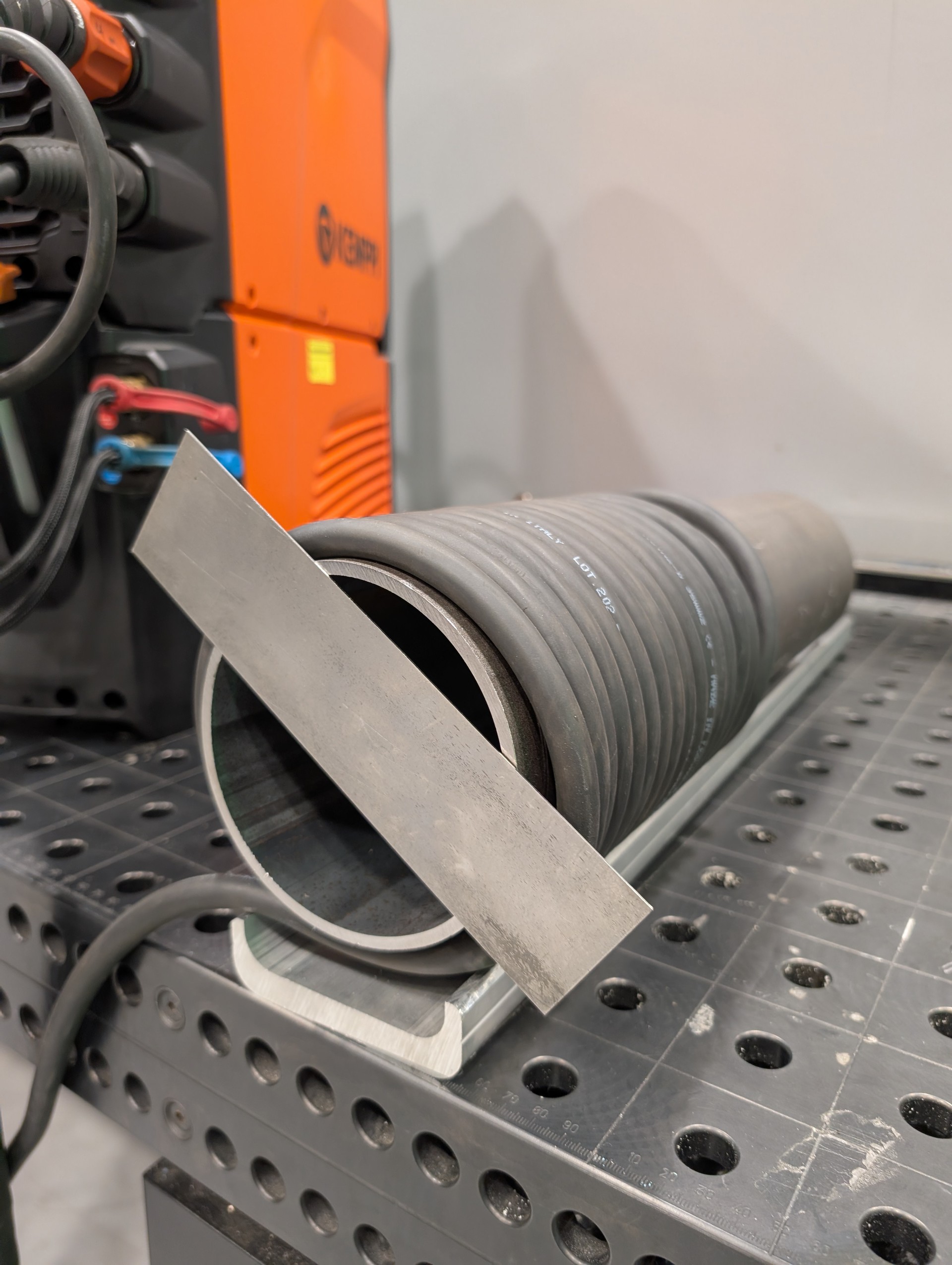 A thin steel plate stays attached to the pipe due to magnetism.