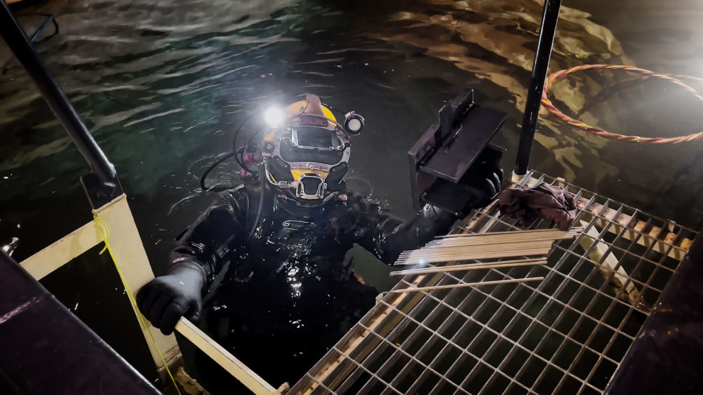 A welder wearing a diving sit and going to water